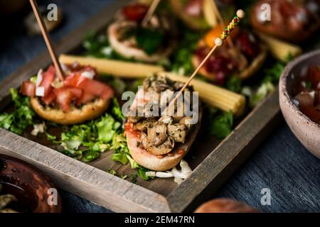 gros plan d'un plateau avec un assortiment de différents pinchos vegan espagnols, fait avec du pain avec différentes garnitures, servi comme encas ou hors-d'œuvre, Banque D'Images