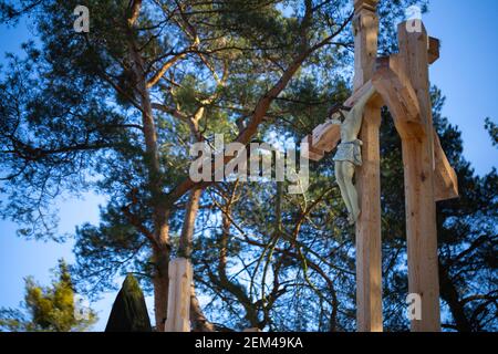 Une figure de Jésus sur une croix de bord de route en bois contre un ciel bleu. Au milieu de la journée, des conditions d'éclairage parfaites. Banque D'Images