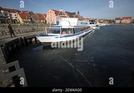 24 février 2021, Mecklembourg-Poméranie occidentale, Waren (Müritz): Couvert de glace foncée est le port de la ville sur le Müritz, les navires à passagers sont amarrés. Malgré les températures douces pendant plus d'une semaine, une couverture de glace arrête toujours l'expédition sur le Müritz. Photo: Bernd Wüstneck/dpa-Zentralbild/dpa Banque D'Images