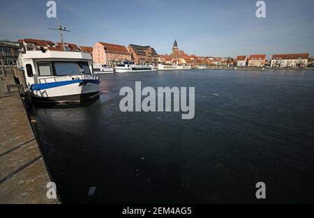 24 février 2021, Mecklembourg-Poméranie occidentale, Waren (Müritz): Couvert de glace foncée est le port de la ville sur le Müritz, les navires à passagers sont amarrés. Malgré les températures douces pendant plus d'une semaine, une couverture de glace arrête toujours l'expédition sur le Müritz. Photo: Bernd Wüstneck/dpa-Zentralbild/dpa Banque D'Images