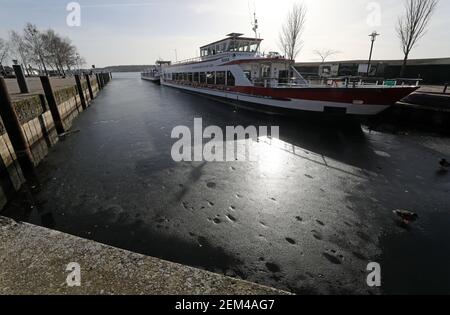 24 février 2021, Mecklembourg-Poméranie occidentale, Waren (Müritz): Le soleil se reflète dans la glace sombre du Müritz devant un navire à passagers. Malgré les températures douces pendant plus d'une semaine, une feuille de glace arrête toujours la navigation sur le Müritz. Photo: Bernd Wüstneck/dpa-Zentralbild/dpa Banque D'Images