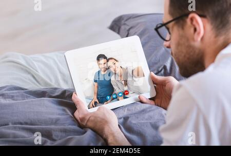Homme effectuant des appels vidéo avec des amis à l'aide d'une tablette Banque D'Images
