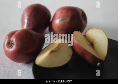 La poire Bartlett rouge porte une véritable forme de poire pyriforme. Une cloche arrondie sur la moitié inférieure du fruit, puis une épaule définitive avec une petite ne Banque D'Images