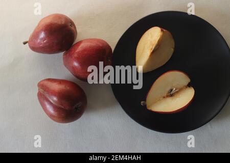 La poire Bartlett rouge porte une véritable forme de poire pyriforme. Une cloche arrondie sur la moitié inférieure du fruit, puis une épaule définitive avec une petite ne Banque D'Images