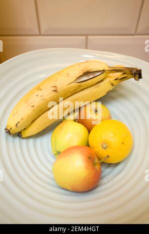 Couper la banane dans un bol de fruits Banque D'Images
