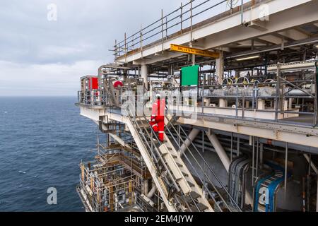 Un travailleur marche dans un escalier sur une installation d'huile offshore ou engin Banque D'Images