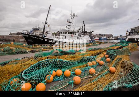 Filets et engins de pêche devant les chalutiers du port de Peterhead à Aberdeenshire, en Écosse, au Royaume-Uni Banque D'Images