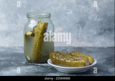 Concombres pickled dans un pot de verre sur fond de marbre Banque D'Images