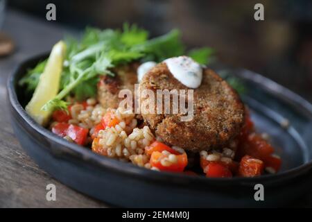 Salmon fishcakes avec salade et d'avoine sur table en bois Banque D'Images