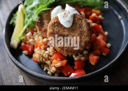 Salmon fishcakes avec salade et d'avoine sur table en bois Banque D'Images