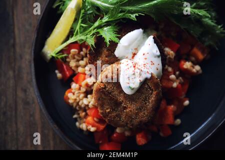 Salmon fishcakes avec salade et d'avoine sur table en bois Banque D'Images