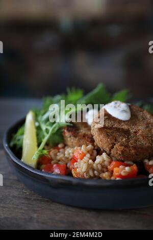 Salmon fishcakes avec salade et d'avoine sur table en bois Banque D'Images