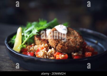 Salmon fishcakes avec salade et d'avoine sur table en bois Banque D'Images