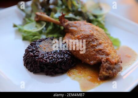 Confit de canard avec du riz et de la salade italienne , style alimentaire Banque D'Images