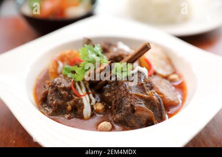 Beef curry massaman avec riz et salade verte sur fond de bois , la nourriture thaïe Banque D'Images