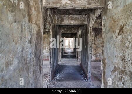 Long et sombre couloir de vieilles ruines abandonnées d'un hôtel à la Termas del Sosneado dans les montagnes andines de l'Argentine, en Amérique du Sud. Banque D'Images