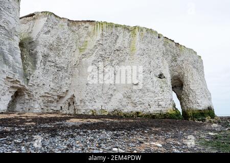 Kingsgate Bay Sea Arch dans le Kent, en Angleterre, par une journée nuageux, avec des rochers et de l'herbe de mer sur la salle de plage pour copier le portrait Banque D'Images