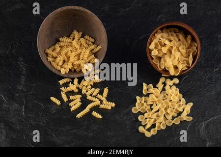 Bols en bois remplis de pâtes farfalle et de pâtes à la girandole crues Banque D'Images