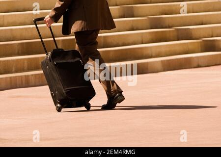 Profil d'un homme d'affaires marchant avec une valise Banque D'Images