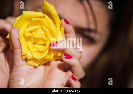 Portrait d'une jeune femme tenant une rose jaune Banque D'Images