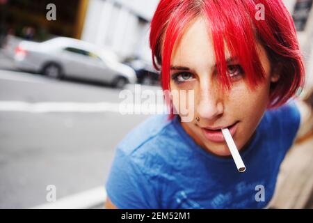 Portrait d'une jeune femme fumant une cigarette Banque D'Images