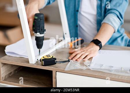 L'homme assemble la table et le mobilier maître de la maison de réparation Banque D'Images