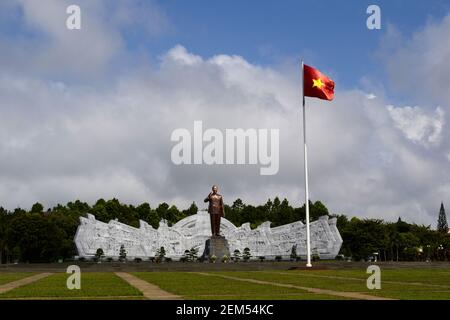 Pleiku, Vietnam - septembre, 2015: Grande place avec monument en bronze du leader communiste Ho Chi Minh et haut mât avec drapeau rouge national avec Banque D'Images