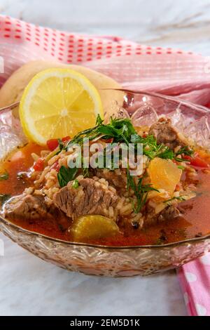 Soupe traditionnelle de bœuf de Kharcho de la Géorgie du pays servie avec un piment sec et une tranche de citron Banque D'Images