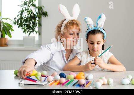 Concept de Pâques. La grand-mère avec sa petite-fille tient des œufs de Pâques à la maison Banque D'Images