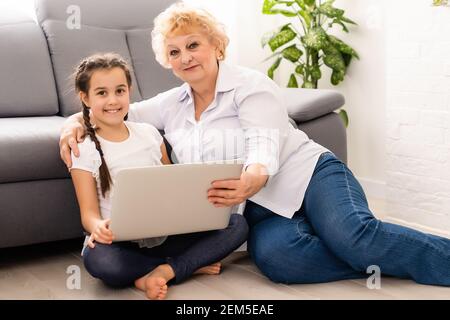 L'enseignement moderne grand-mère petit-enfant comment utiliser un ordinateur portable à la maison Banque D'Images