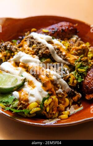 Bol de riz jamaïcain au poulet jerk avec des plantains sucrés et chauds sauce Banque D'Images