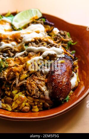 Bol de riz jamaïcain au poulet jerk avec des plantains sucrés et chauds sauce Banque D'Images