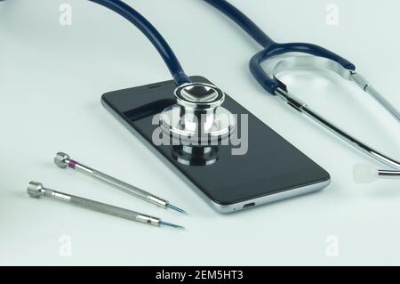 Stéthoscope sur le smartphone et les tournevis. Concept de réparation et de service téléphonique. Concept un état de santé de l'appareil. Banque D'Images