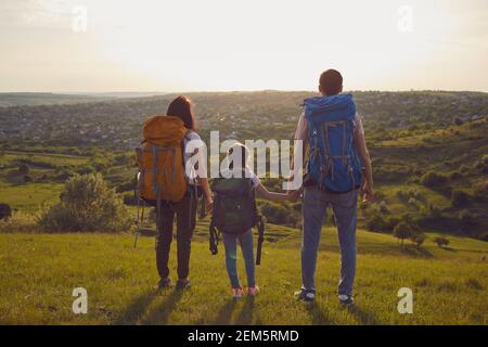 Famille avec sacs à dos. Mère de randonneur père et fille avec sacs à dos dans la nature. Vue arrière. Banque D'Images