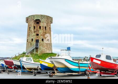 Le Hocq Tour britannique de défense côtière ronde avec des bateaux colorés en premier plan, bailiwick de Jersey, îles Anglo-Normandes Banque D'Images