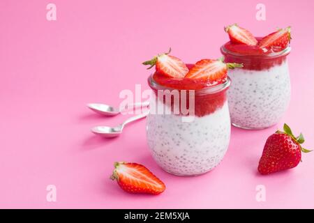 Pudding au chia et à la fraise dans les deux pots en verre sur fond rose. Copier l'espace. Gros plan. Banque D'Images