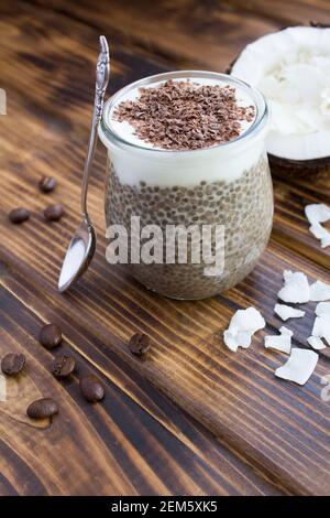 Café au lait de chia, au lait de coco et au chocolat dans le pot en verre sur fond de bois brun. Emplacement vertical. Banque D'Images