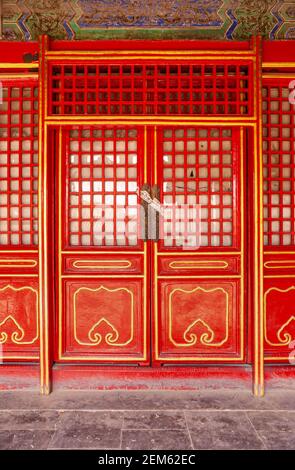 Beijing, Chine - 27 avril 2010 : Cité interdite. Gros plan de porte en bois rouge fermée avec cadres jaunes. Banque D'Images