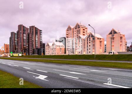 Moden immeubles d'appartements le long d'une route urbaine importante chaleureusement éclairée par soleil de minuit en été Banque D'Images