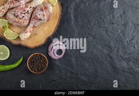 Vue du dessus. Cuisses de poulet crues avec oignon et poivre Banque D'Images