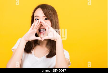 Portrait heureux asiatique belle jeune femme jeune ado se tenant grand shout avec les mains à la bouche suivante donnant excité positif regardant l'appareil photo isolé, Banque D'Images