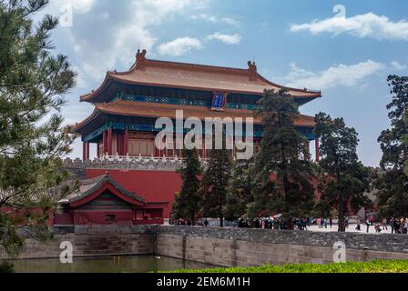 Beijing, Chine - 27 avril 2010 : porte rouge de la construction divine sans issue comme sortie de la Cité interdite côté nord sous bleu ciel nuageux. Douves et arbres verts. Banque D'Images