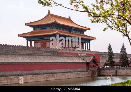 Beijing, Chine - 27 avril 2010 : fossé, remparts et porte rouge de la construction divine de prouesses comme sortie de la Cité interdite côté nord sous un paysage de nuages d'argent. Banque D'Images