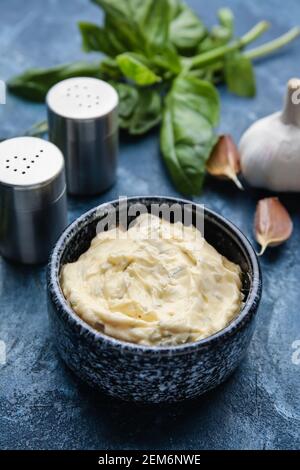 Bol avec savoureux beurre à l'ail sur fond de couleur Banque D'Images