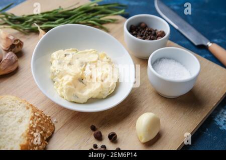 Bol avec beurre à l'ail et ingrédients sur fond de couleur, gros plan Banque D'Images