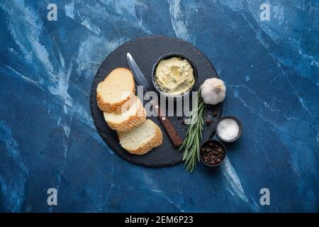Tranches de pain, beurre à l'ail et ingrédients sur fond de couleur Banque D'Images