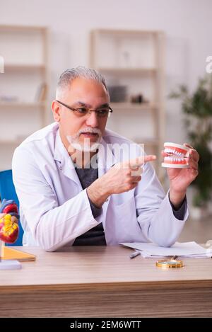 Ancien professeur de dentiste assis dans la salle de classe Banque D'Images