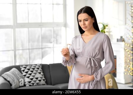 Jeune femme enceinte avec une cigarette cassée à la maison. Concept de refus de mauvaise habitude Banque D'Images