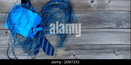 Blue présente composé d'une cravate rayée, d'une boîte cadeau et de confetti sur des planches de bois abîmés pour le concept de la fête des Pères heureux Banque D'Images