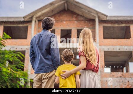 Famille mère, père et fils regardant leur nouvelle maison en construction, la planification de l'avenir et rêver. Une jeune famille rêvant d'une nouvelle maison Banque D'Images